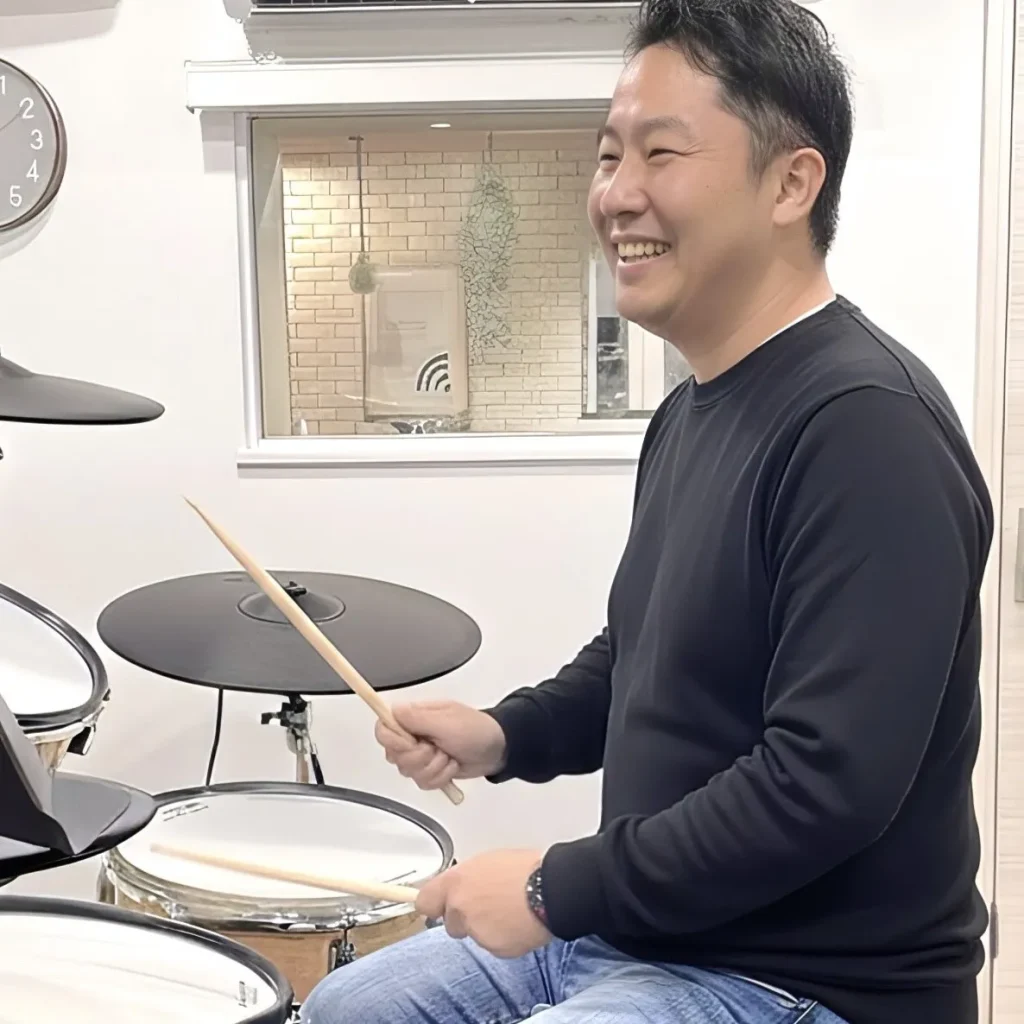 男性がドラムを叩いている画像